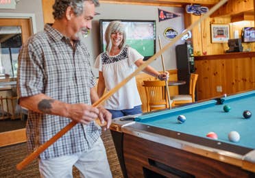 Two guests playing billiards in the Beartree Bar at Oak n' Spruce Resort in South Lee, Massachusetts.