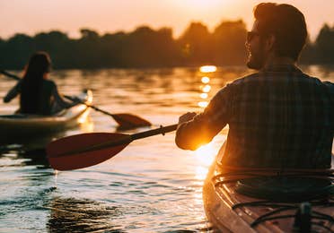 Man kayaking at sunset.