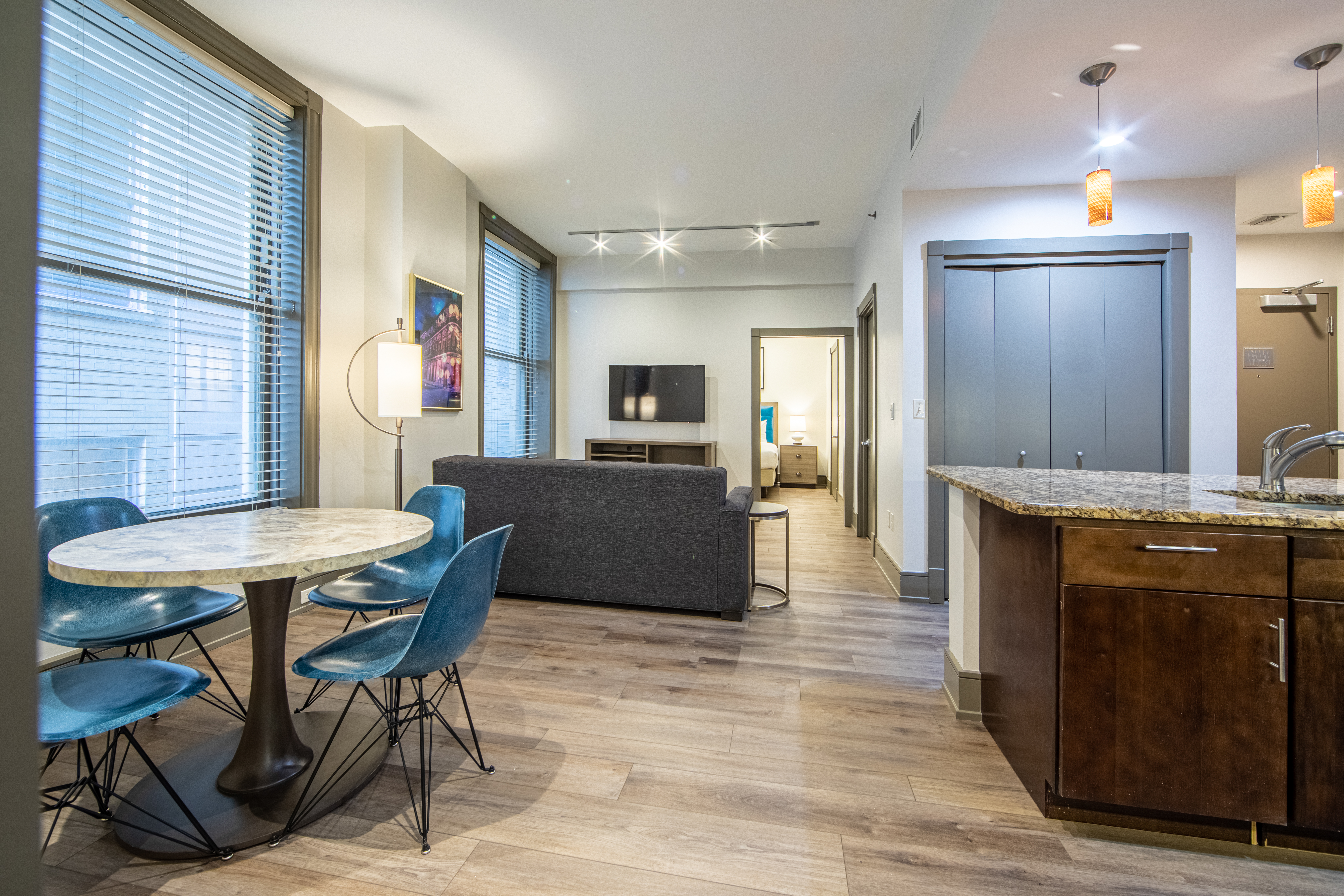 Two bedroom villa living area with couch, two windows, TV and dining area at New Orleans Resort in Louisiana.