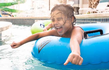 Author, Brenda Rivera Stearns' daughter, Victoria, floating along the lazy river in a blue innertube at our South Beach resort in Myrtle Beach, South Carolina.