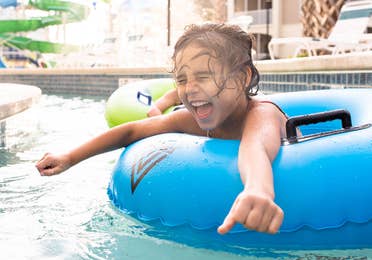 Author, Brenda Rivera Stearns' daughter, Victoria, floating along the lazy river in a blue innertube at our South Beach resort in Myrtle Beach, South Carolina.