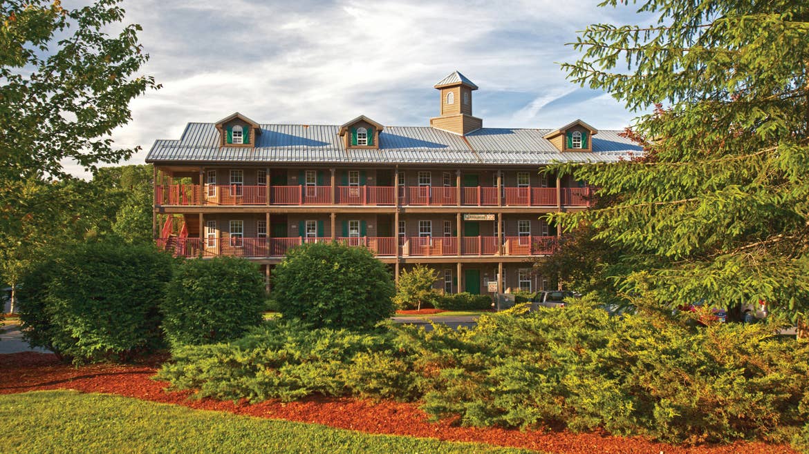A beautiful shot of an Oak n' Spruce Resort building with lush greenery in the foreground