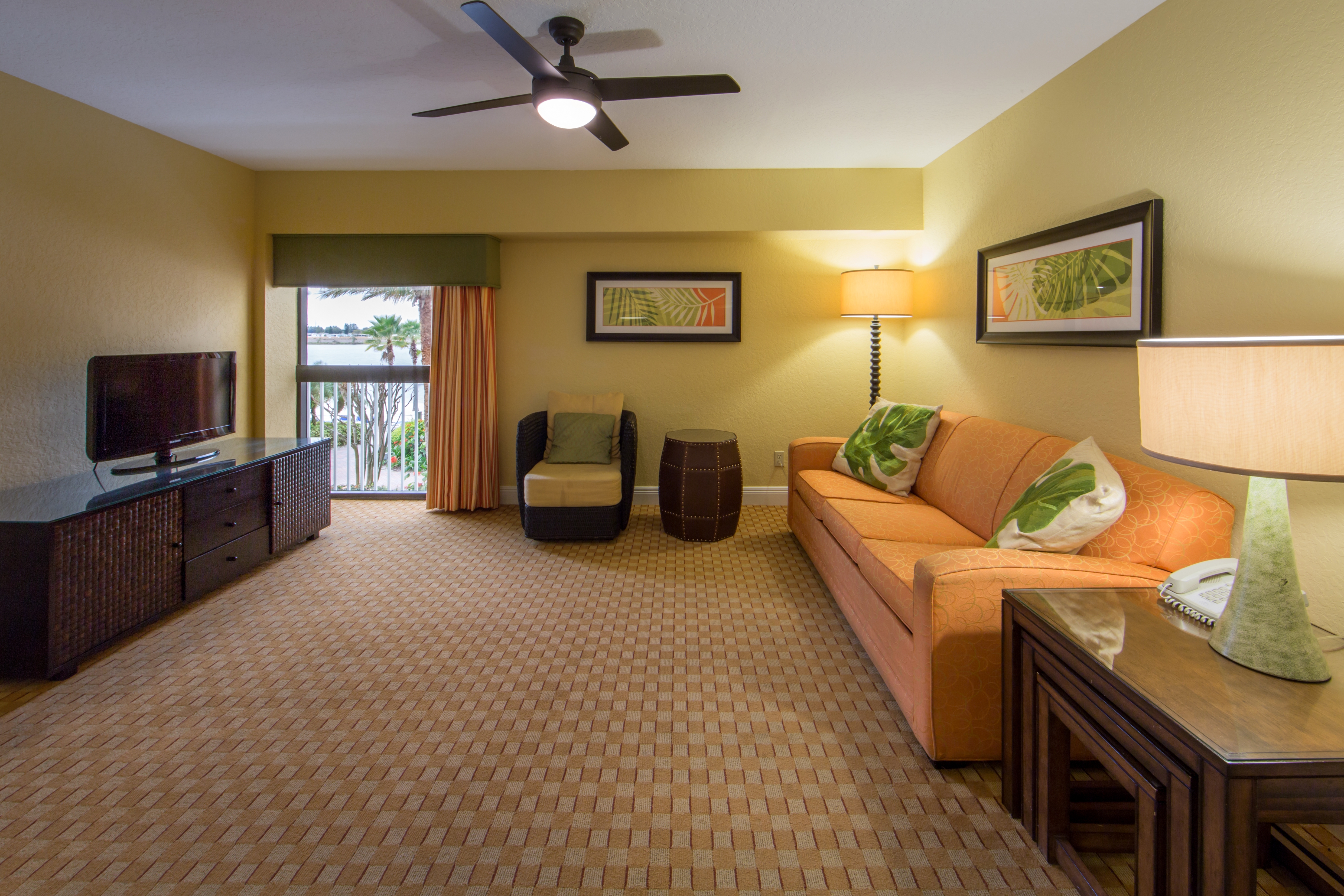 Living room with couch, accent chair, and flat screen TV in West Village at Orange Lake Resort near Orlando, FL