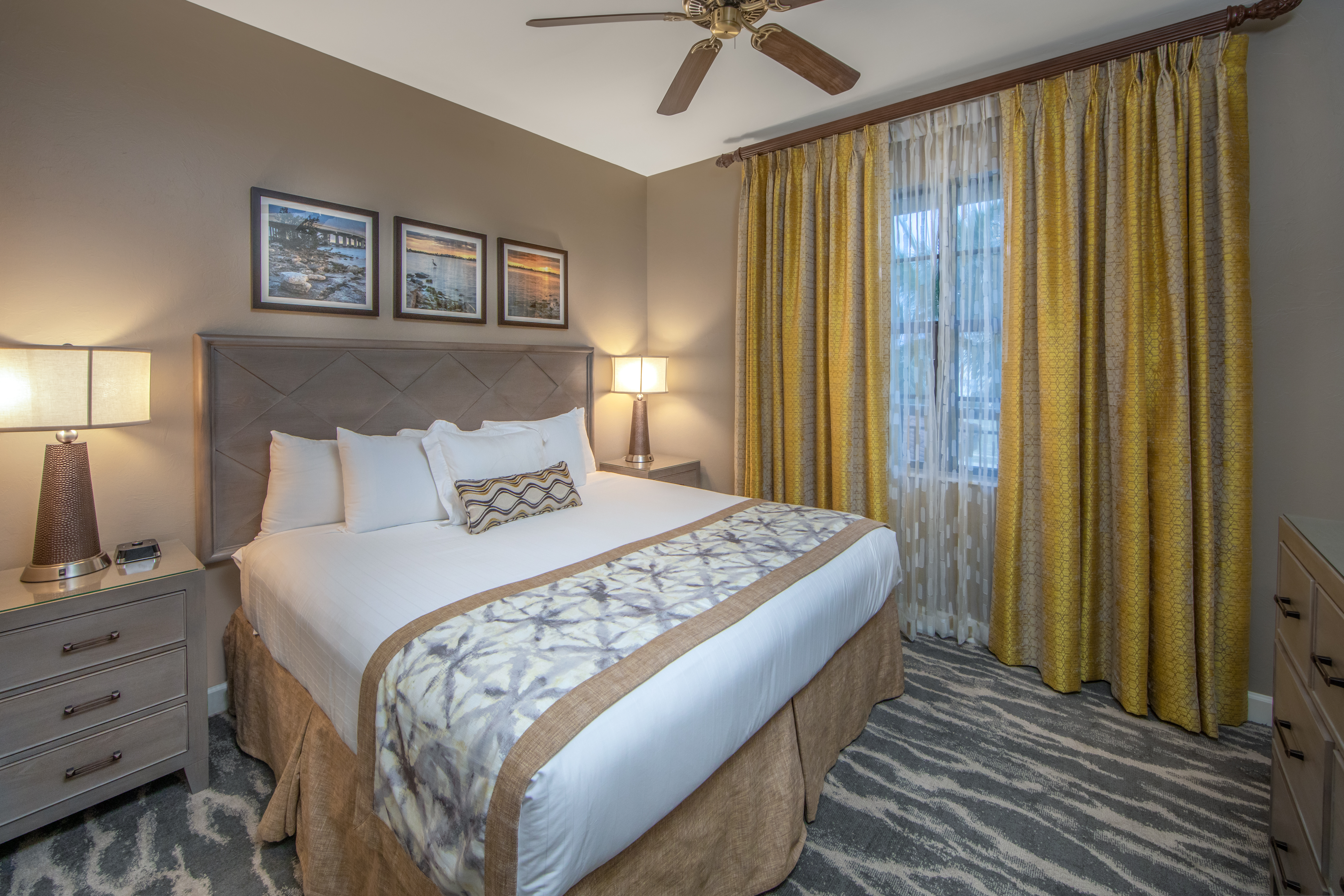 Bedroom with king bed, ceiling fan, and large window in a three-bedroom villa at Sunset Cove Resort in Marco Island, Florida