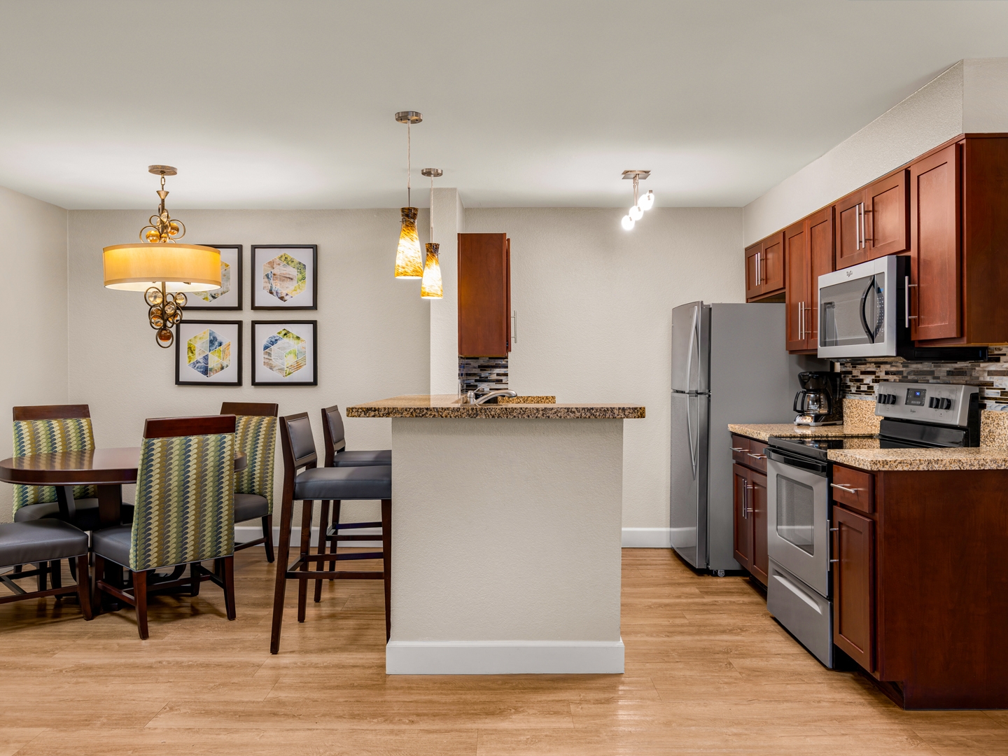 Full kitchen and dining area with granite counters and modern lighting.
