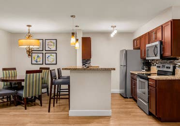 Full kitchen and dining area with granite counters and modern lighting.