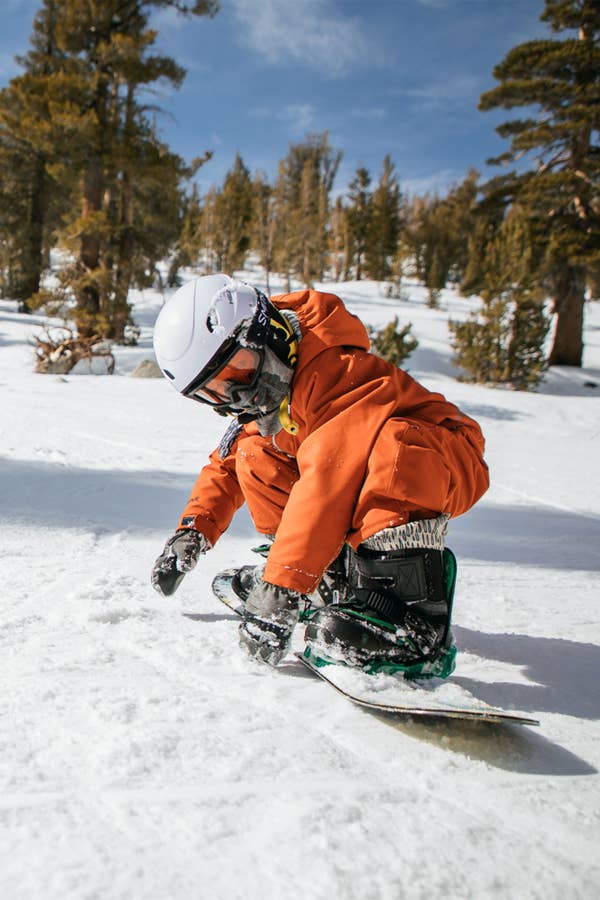 Young boy snowboarding down snowy mountain near Tahoe Ridge Resort in Stateline, Nevada.