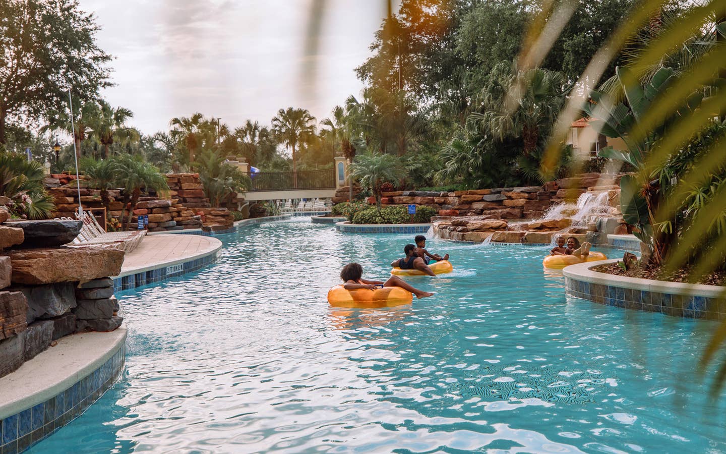 Family floating in orange tubes in lazy river at Orange Lake Resort near Orlando, Florida.