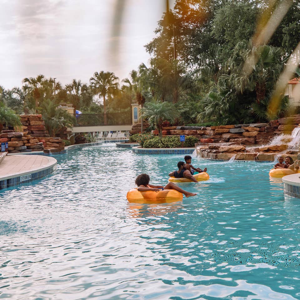 Family floating in orange tubes in lazy river at Orange Lake Resort near Orlando, Florida.