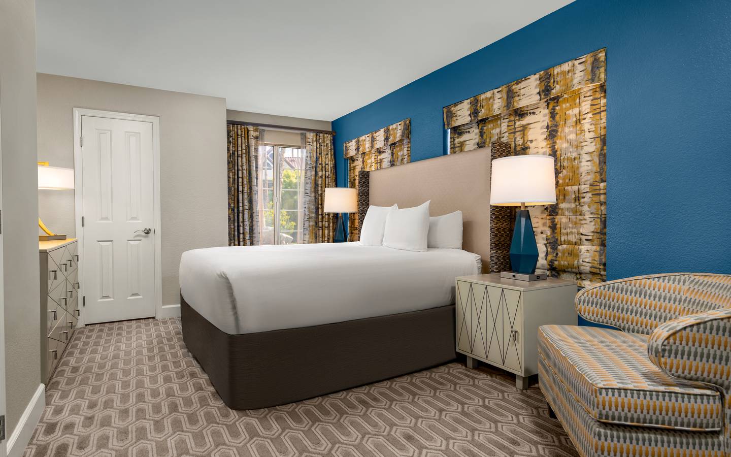 Bright, modern bedroom with bold hues and cozy seating.