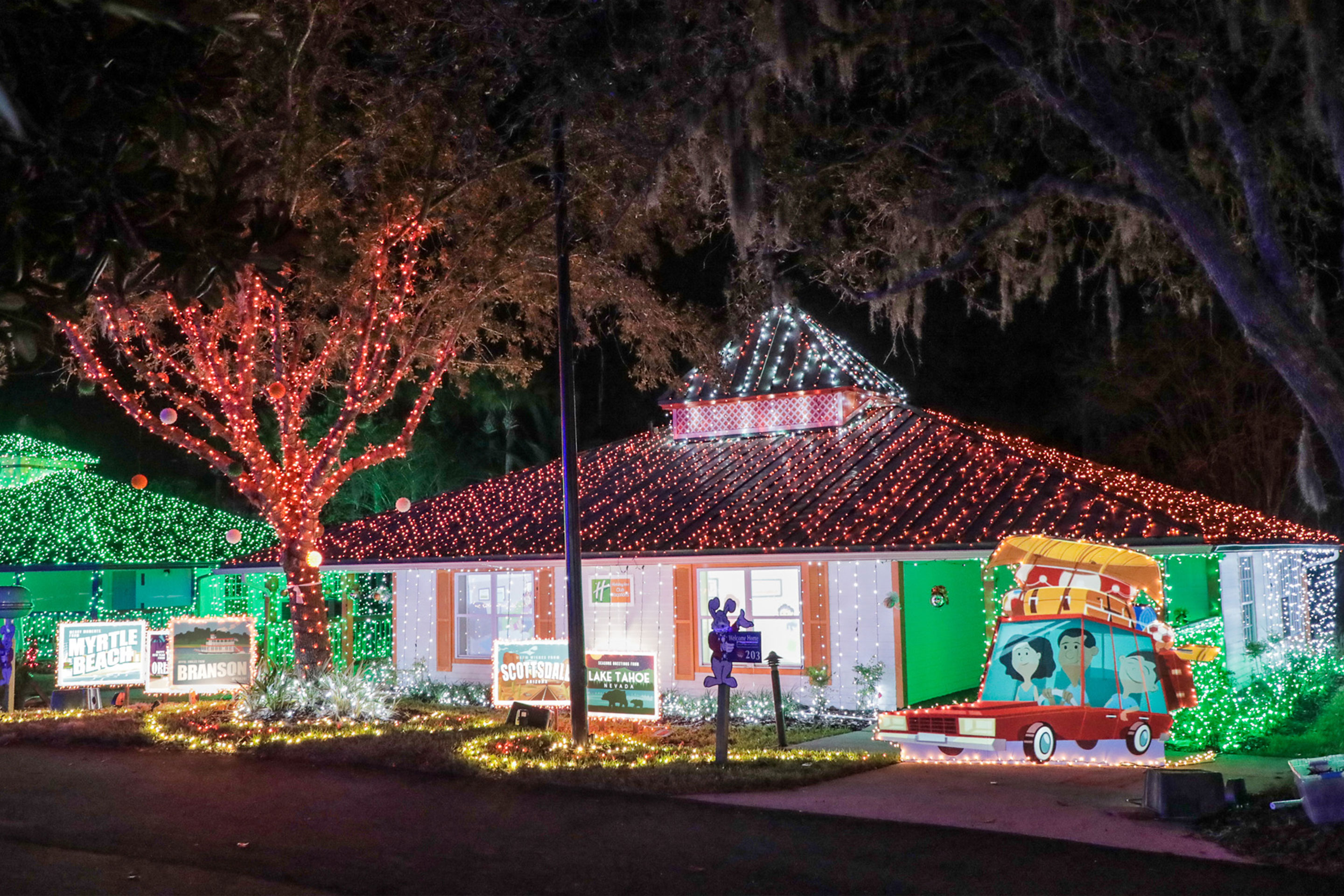 An exterior shot of our HICV villa decorated for the 'Night of a Million Lights' event complete with oversized travel postcards and a family station wagon.