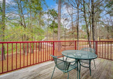 Patio with table and two chairs in a two bedroom cabin at Piney Shores Resort in Conroe, Texas