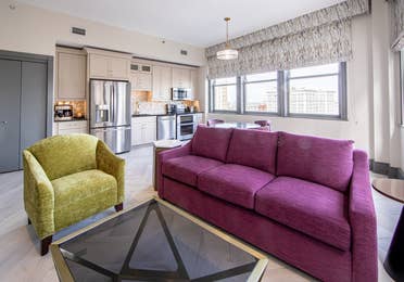 Living room and kitchen in a one-bedroom Signature Collection villa at New Orleans Resort in Louisiana.