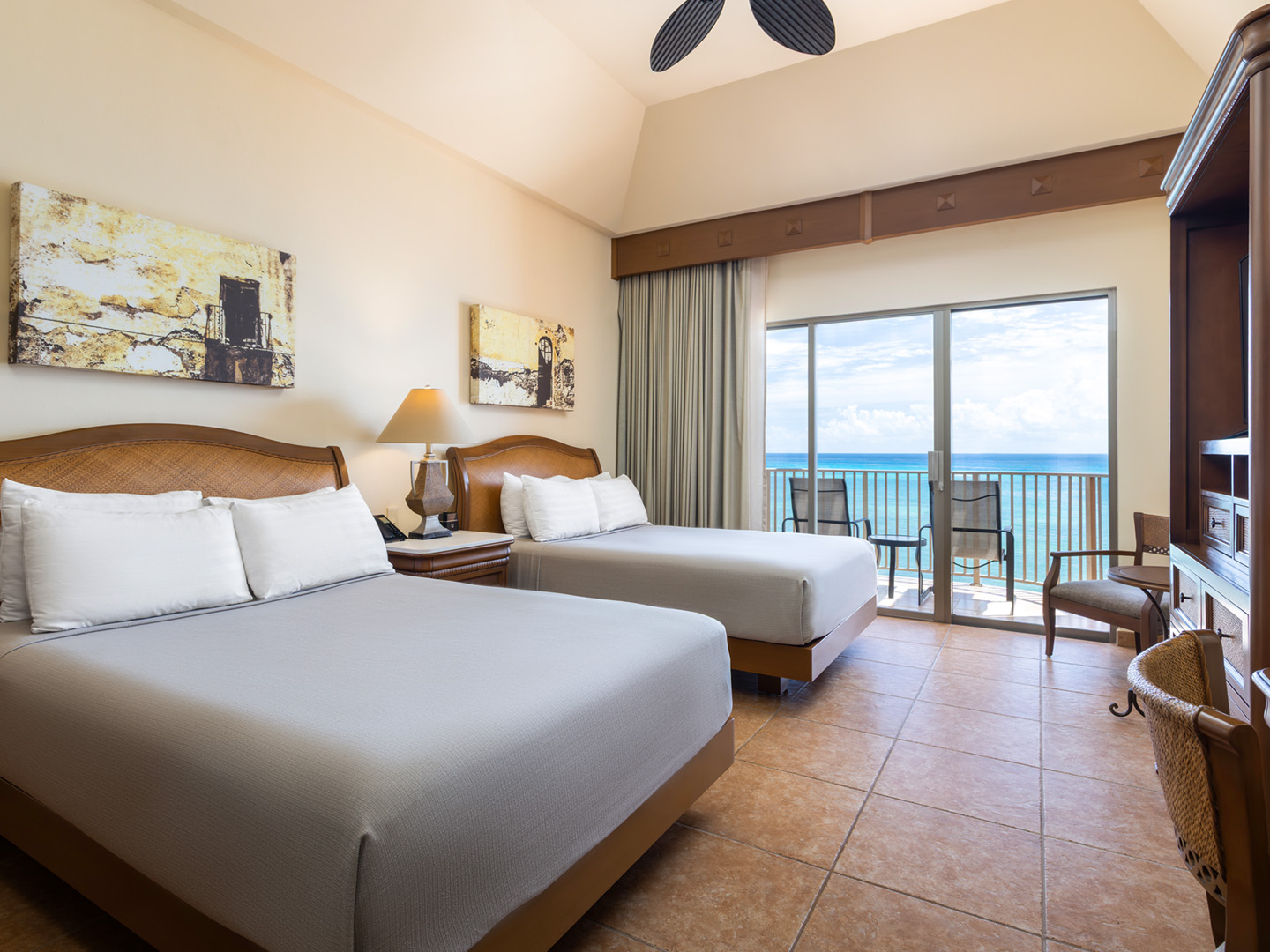 Oceanview bedroom with balcony and two comfortable beds.