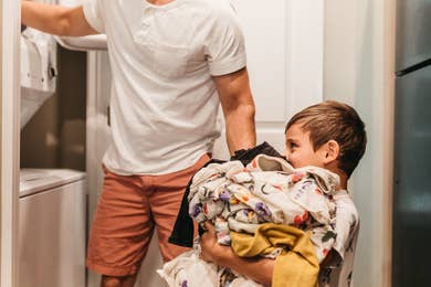 Toddler attempting to put laundry in the washer in a villa at Orange Lake Resort near Orlando, Florida