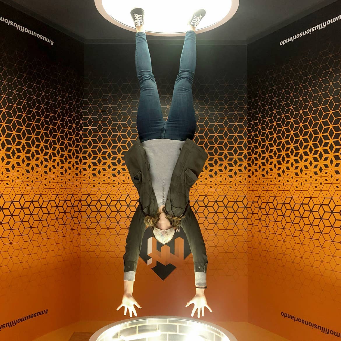 A woman doing what appears to be a handstand at Museum of Illusions at ICON park.
