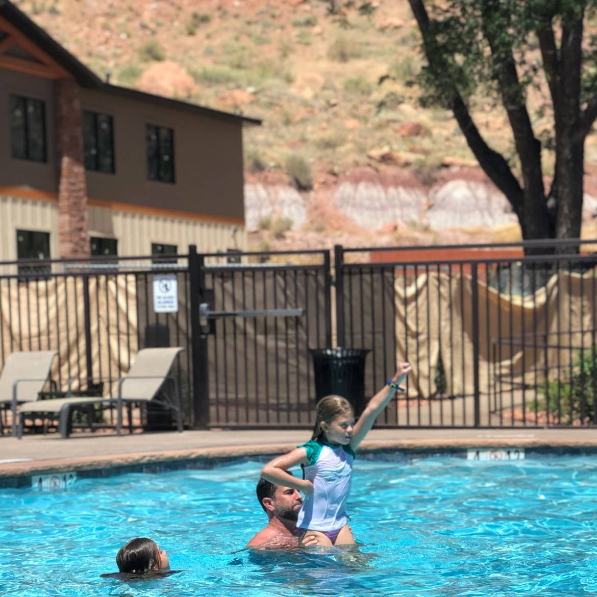 Josh and Kyndall play in the pool in the distance.