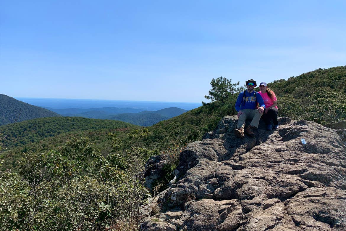 Featured Contributor, Ashley Fraboni (right) and Fiancé, Nicholas (left) sit atop a rock a Shenandoah National Park.