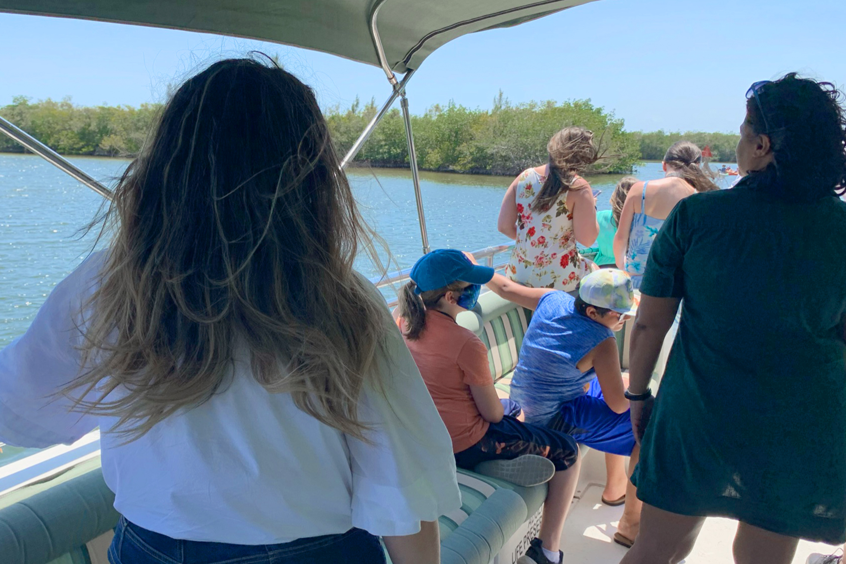 A group of guests sit on a boat during WildeSide Eco Tour.