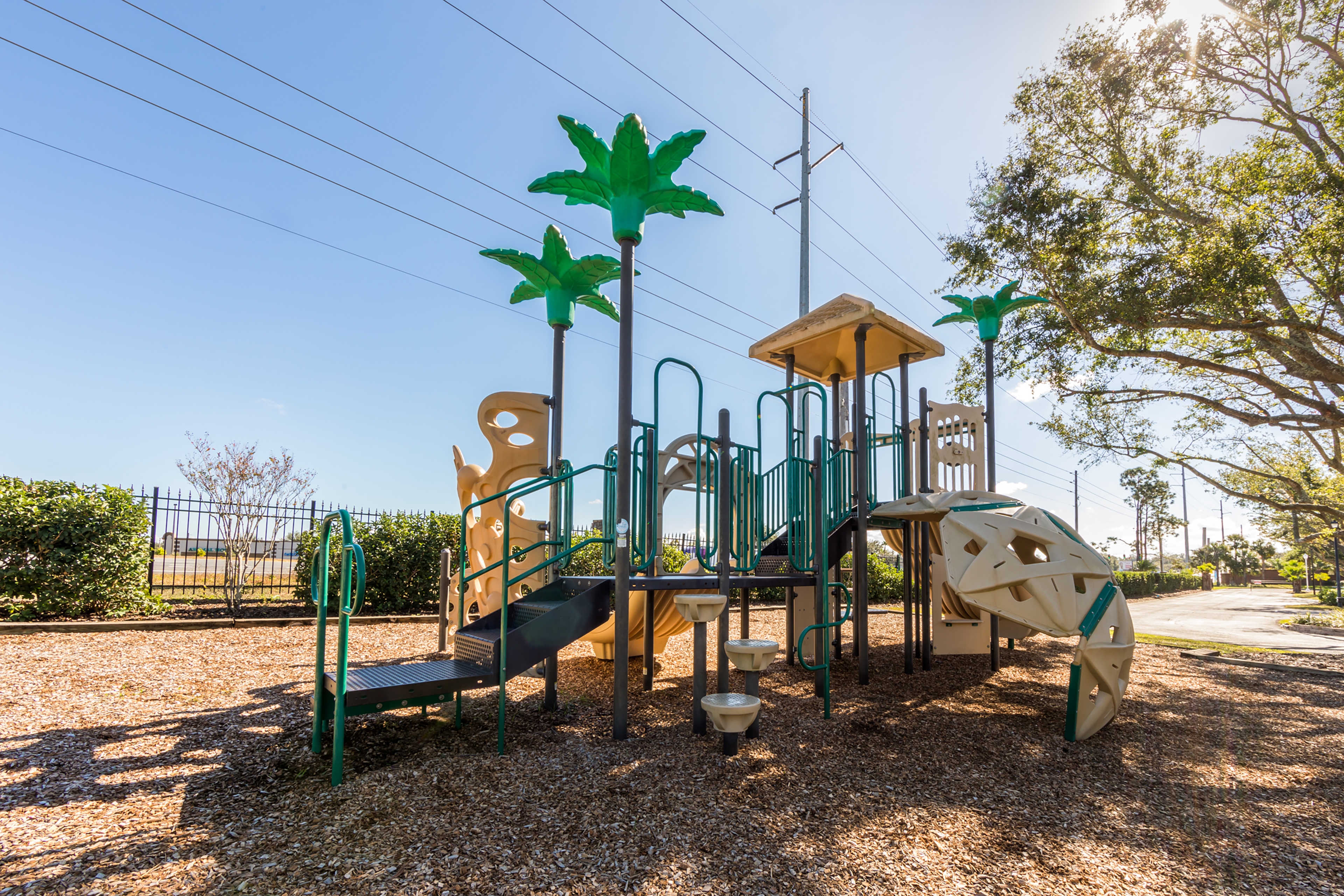 Outdoor playground with palm trees at Orlando Breeze Resort in Florida.