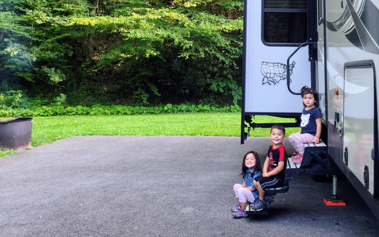Angelica's children sitting on the steps of their RV.