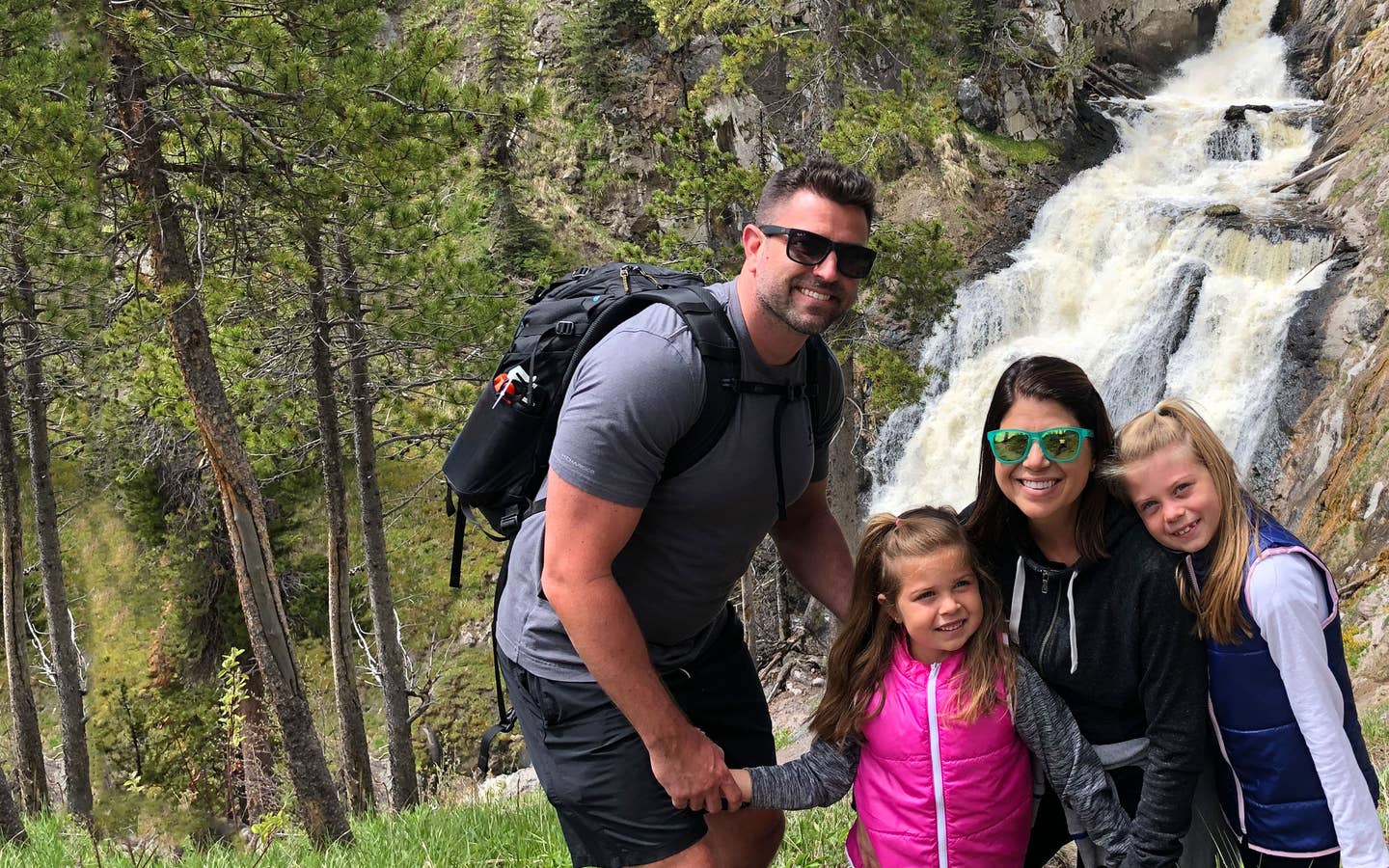 Author, Chris Johnston (middle-right), stands in front of the Mystic Falls at Yellowstone National Park with her husband, Josh (far-left), and daughters, Kyndall (far-right), and Kyler (middle-left).