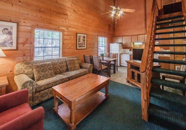 Living room in a one-bedroom log cabin at Holly Lake Resort in Holly Lake Ranch, Texas.