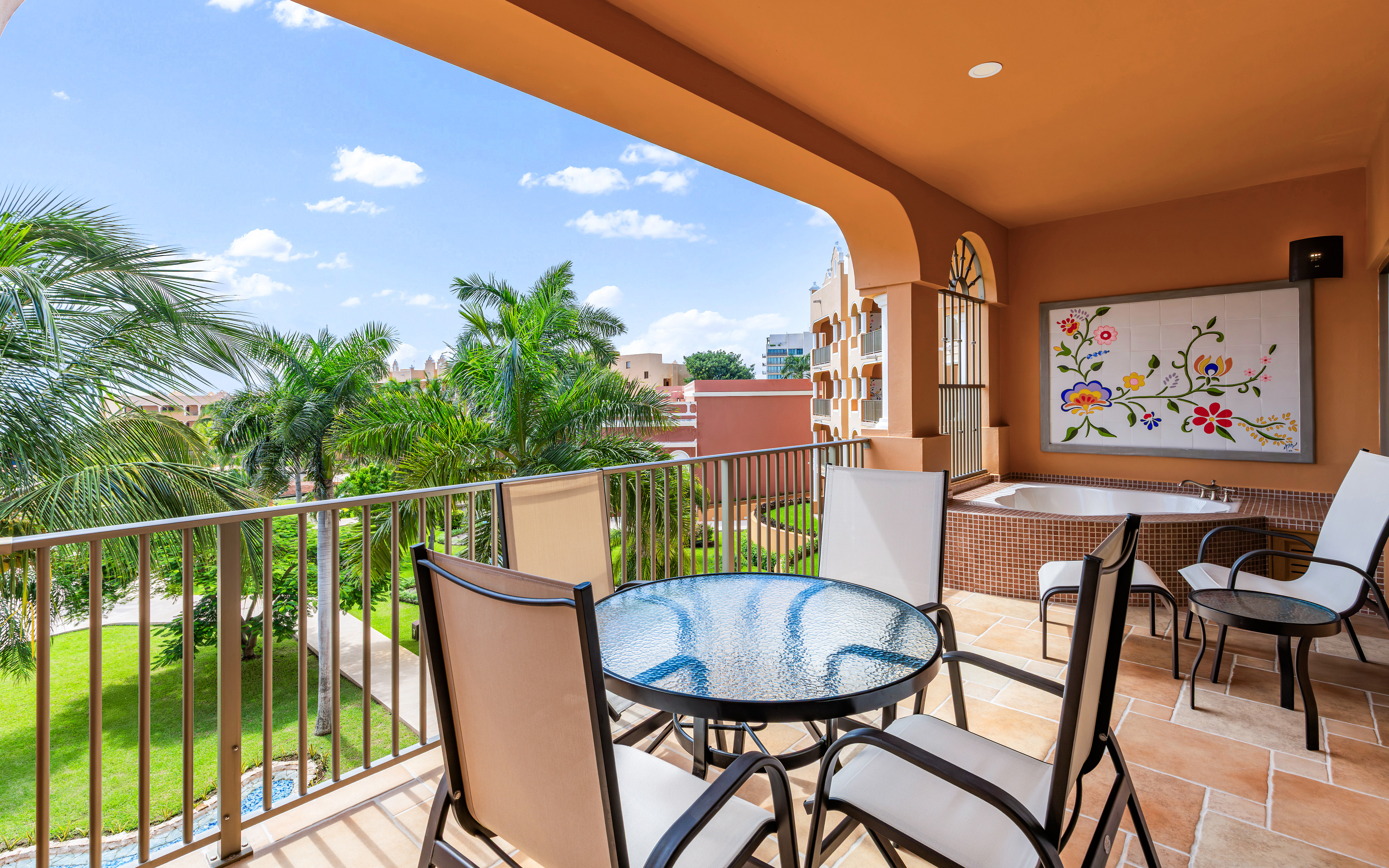 Garden-view balcony with dining set and soaking tub.