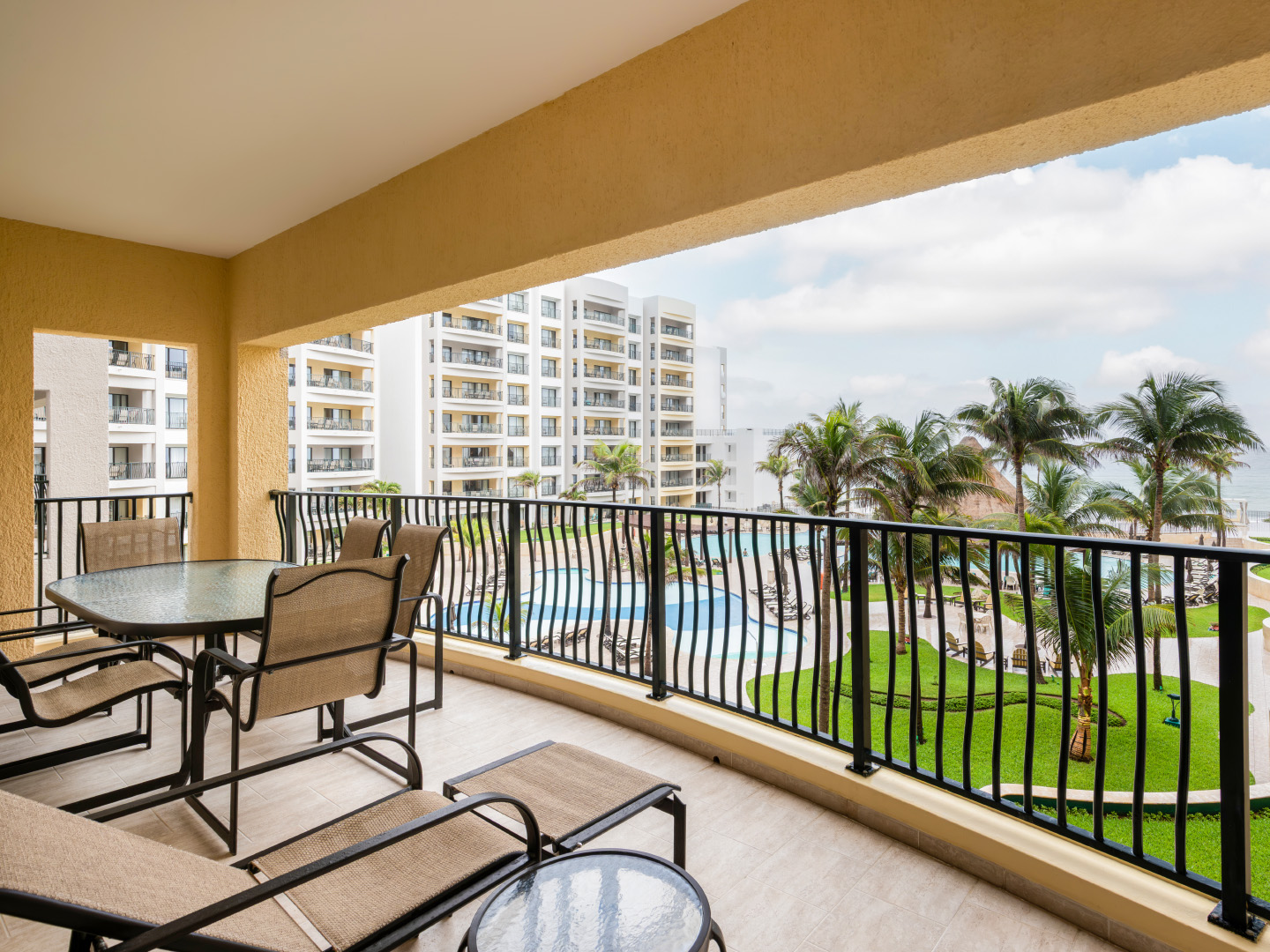 Spacious resort-view balcony with loungers and dining set. 