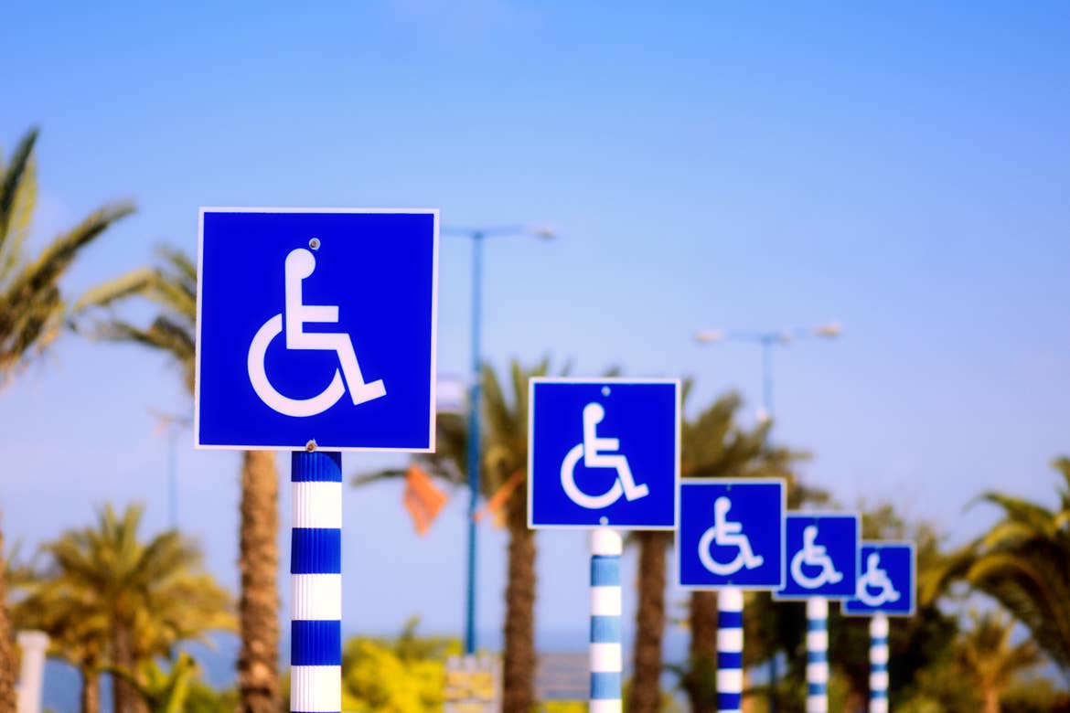 Multiple Wheelchair Parking signs placed near a beachfront.