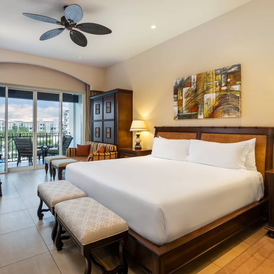 Master suite bedroom with king bed, balcony, and sitting area.