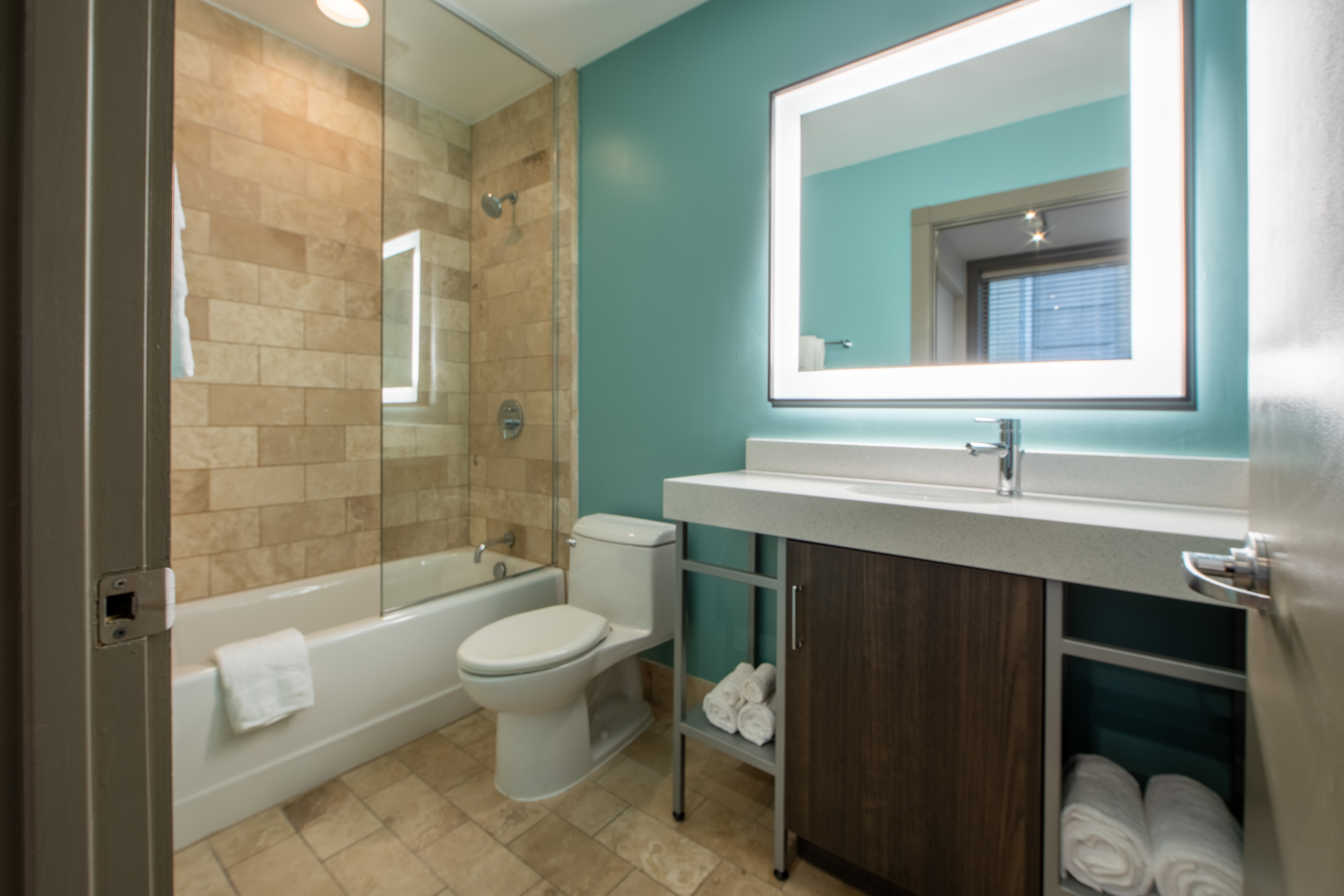 Two bedroom villa bathroom with shower/tub combination, toilet and sink with lighting at New Orleans Resort in Louisiana.