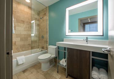 Two bedroom villa bathroom with shower/tub combination, toilet and sink with lighting at New Orleans Resort in Louisiana.