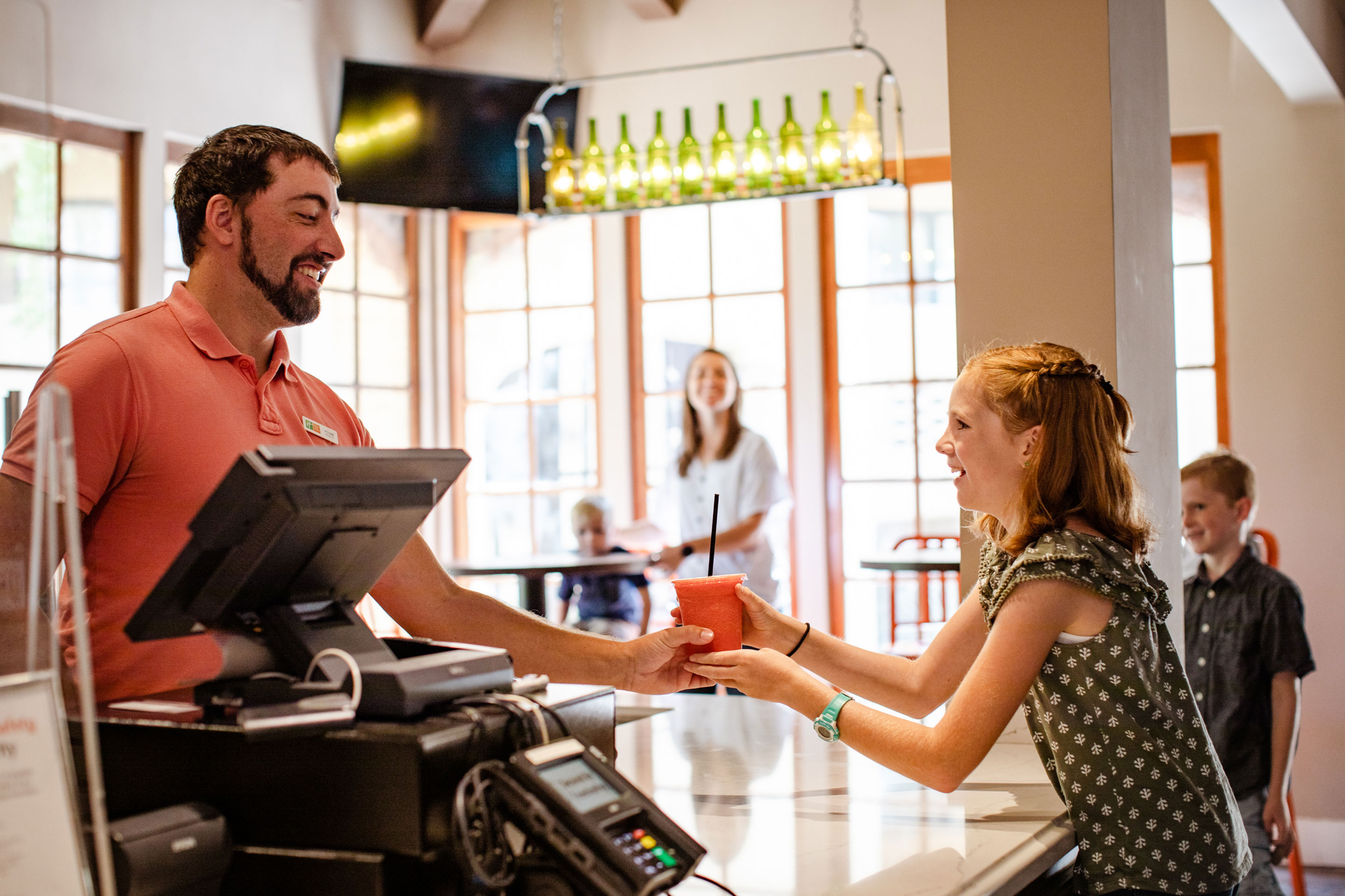 A HICV team member hands over a smoothie to Jessica Averett's daughter.