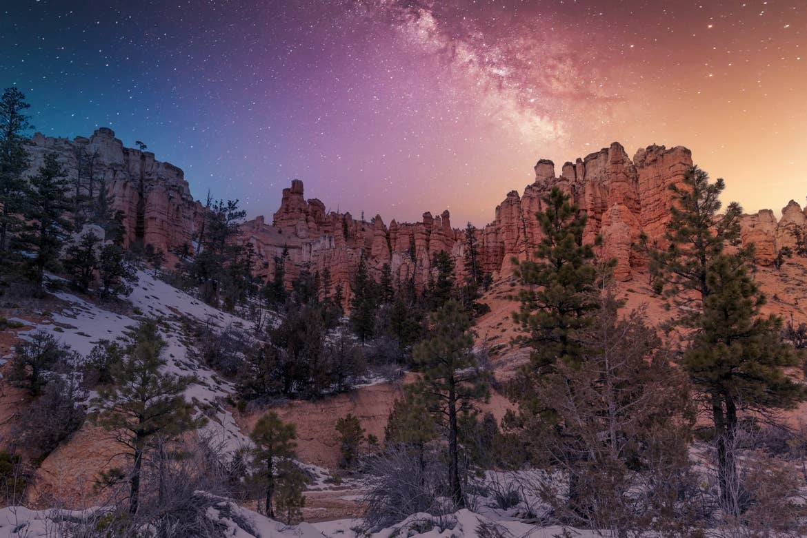 Bryce Canyon National Park night view with colorful sky and bright stars.