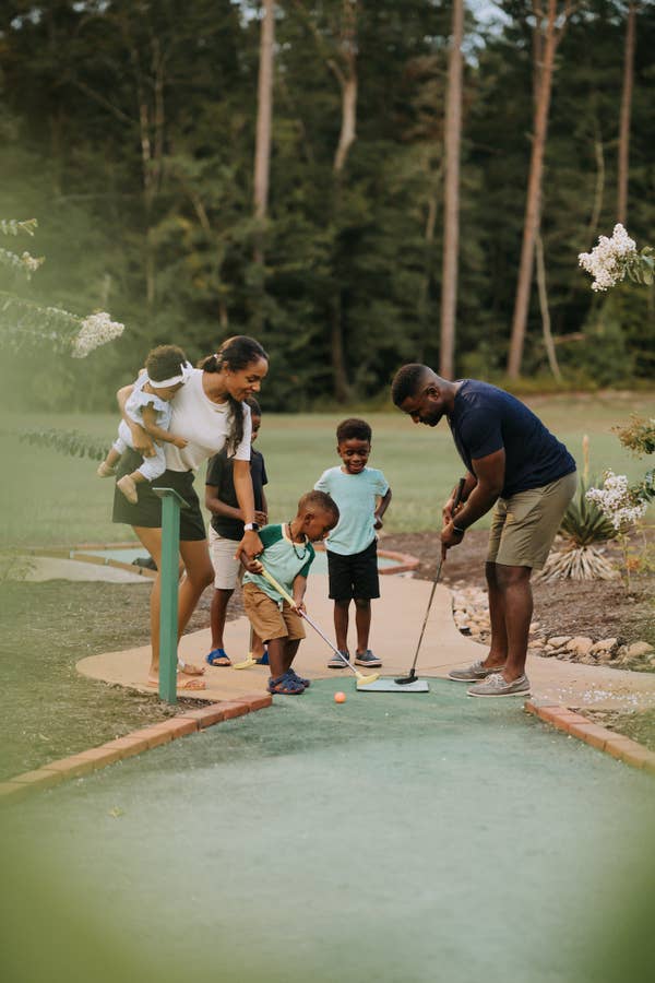 Family of five playing mini golf at Williamsburg Resort in Virginia.