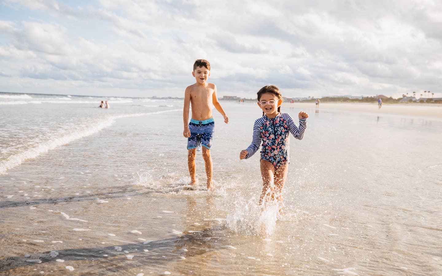 Two children running on beach near Cape Canaveral Beach Resort in Florida.