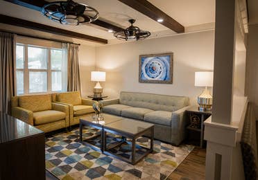 Living room with a couch and two chairs in a two-bedroom Signature Collection villa at Cape Canaveral Beach Resort.