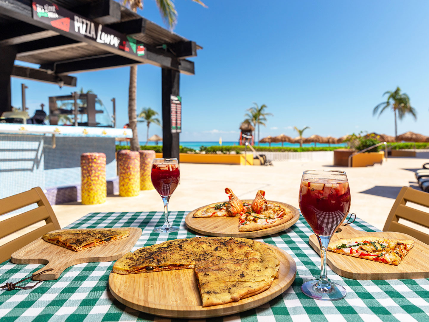 The Pizza Luna, Calzone pizza, lobster pizza and 2 glasses of sangria on a beachfront table at the Royal Haciendas, at Playa del Carmen, Mexico