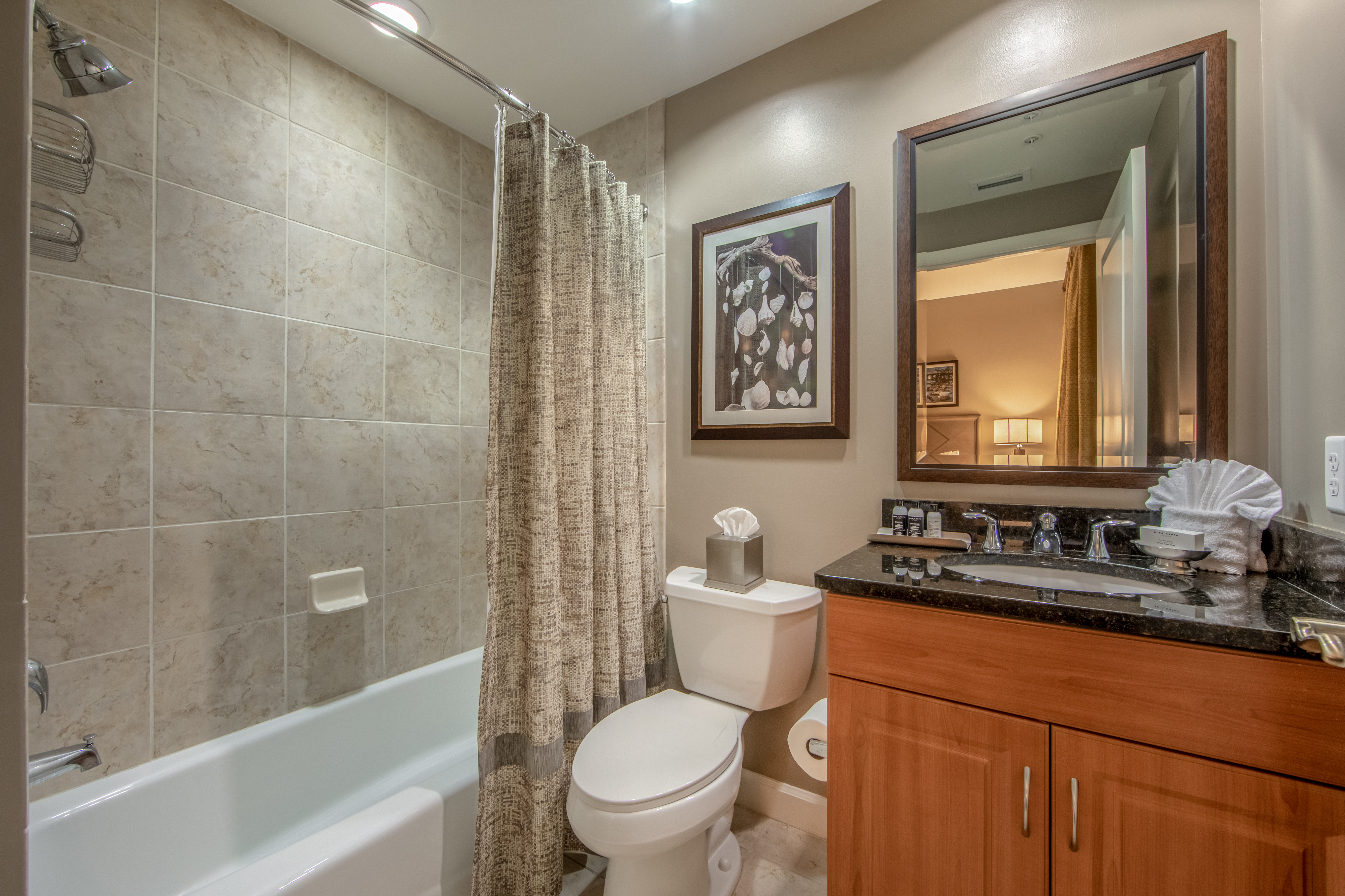 Bathroom with shower/tub combination, sink with mirror, and toilet in a three-bedroom villa at Sunset Cove Resort in Marco Island, Florida