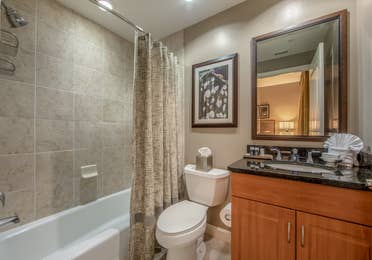 Bathroom with shower/tub combination, sink with mirror, and toilet in a three-bedroom villa at Sunset Cove Resort in Marco Island, Florida