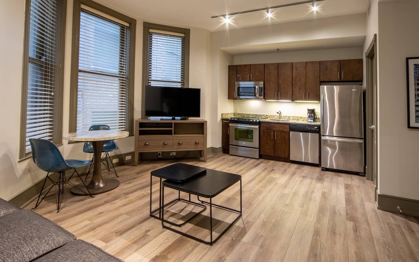 One bedroom villa living area with couch, three windows, TV and full kitchen at New Orleans Resort in Louisiana.