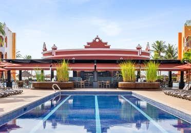 A sunlit lap pool paired with relaxed poolside dining.