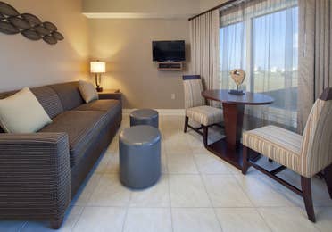 Living room with couch, flat screen TV, and large window with seating area in a villa at Galveston Beach Resort