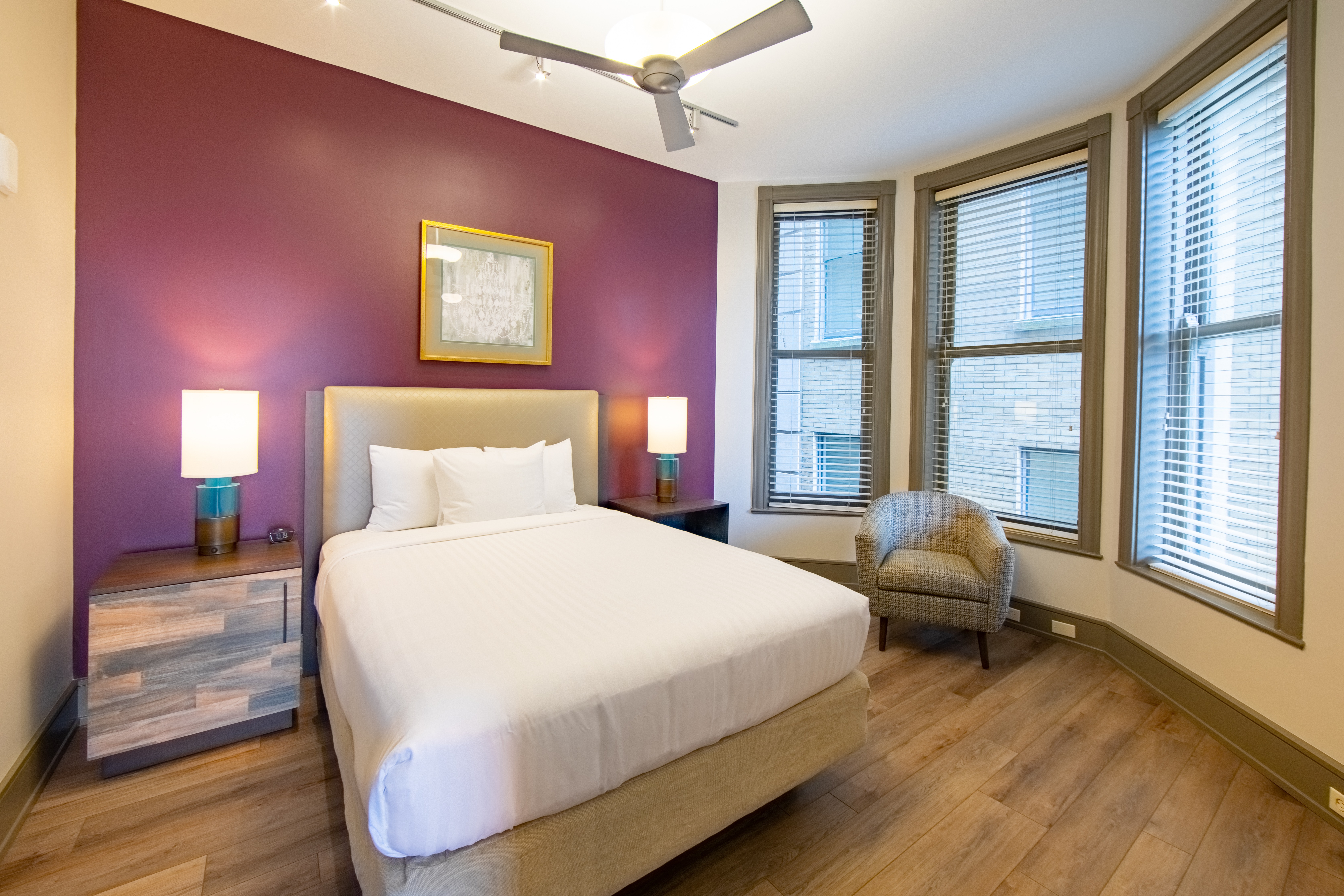 One bedroom villa with bed, three windows and ceiling fan at New Orleans Resort in Louisiana.