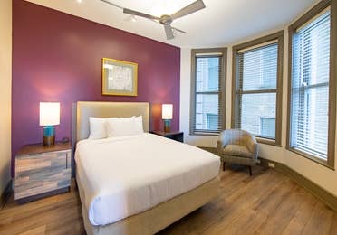 One bedroom villa with bed, three windows and ceiling fan at New Orleans Resort in Louisiana.