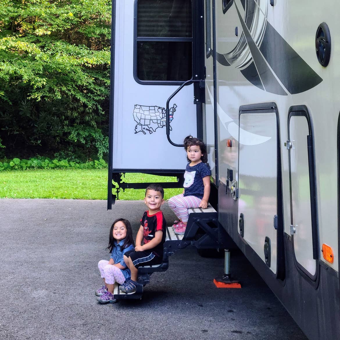 Angelica's children sitting on the steps of their RV.