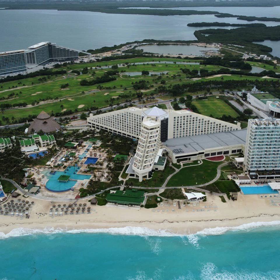 Aerial view of Cancun golf course with oceanfront resorts.
