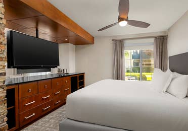Spacious bedroom with plush bedding and modern in-room entertainment.