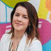 Close-up of Jennifer Harmon in front of a colorful wall.